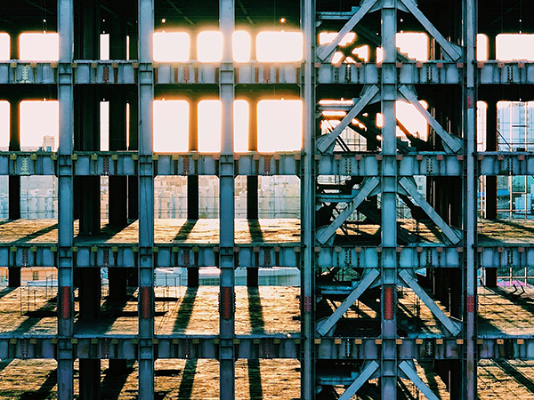 group-lab-theory-of-computation-scaffold Metal scaffolding of a skyscraper under construction with sunlight peeking through on the horizon