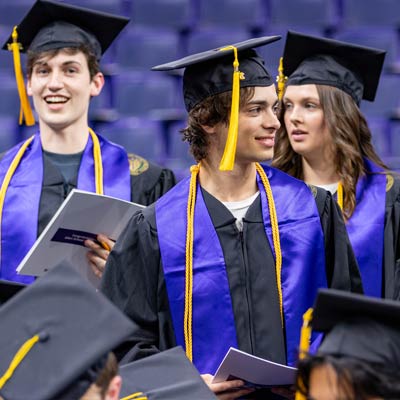 Small group of Allen School students wearing their cap and gown on graduation day 2024.