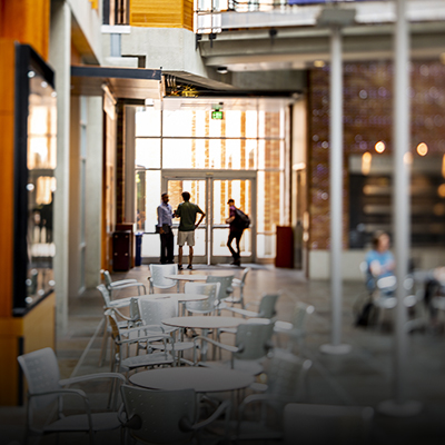 Allen Center atrium with a group of students standing in front of door near light-wall installation