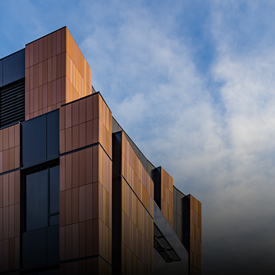 Partial shot of the Gates Center facade against a blue sky with wispy clouds