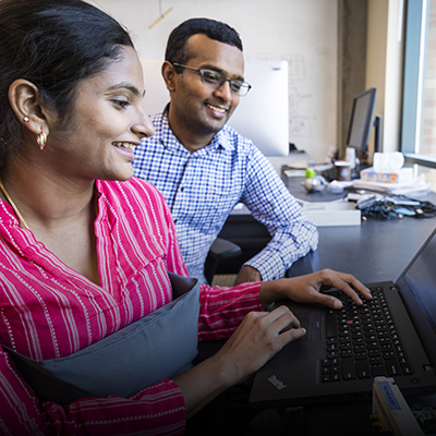 A student and faculty member work together at a laptop