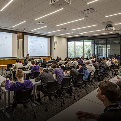 Students sitting around tables attending class.