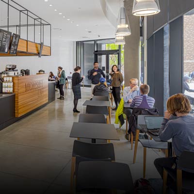 Students sitting in the Microsoft Cafe, enjoying beverages, located in the Gates Center building.