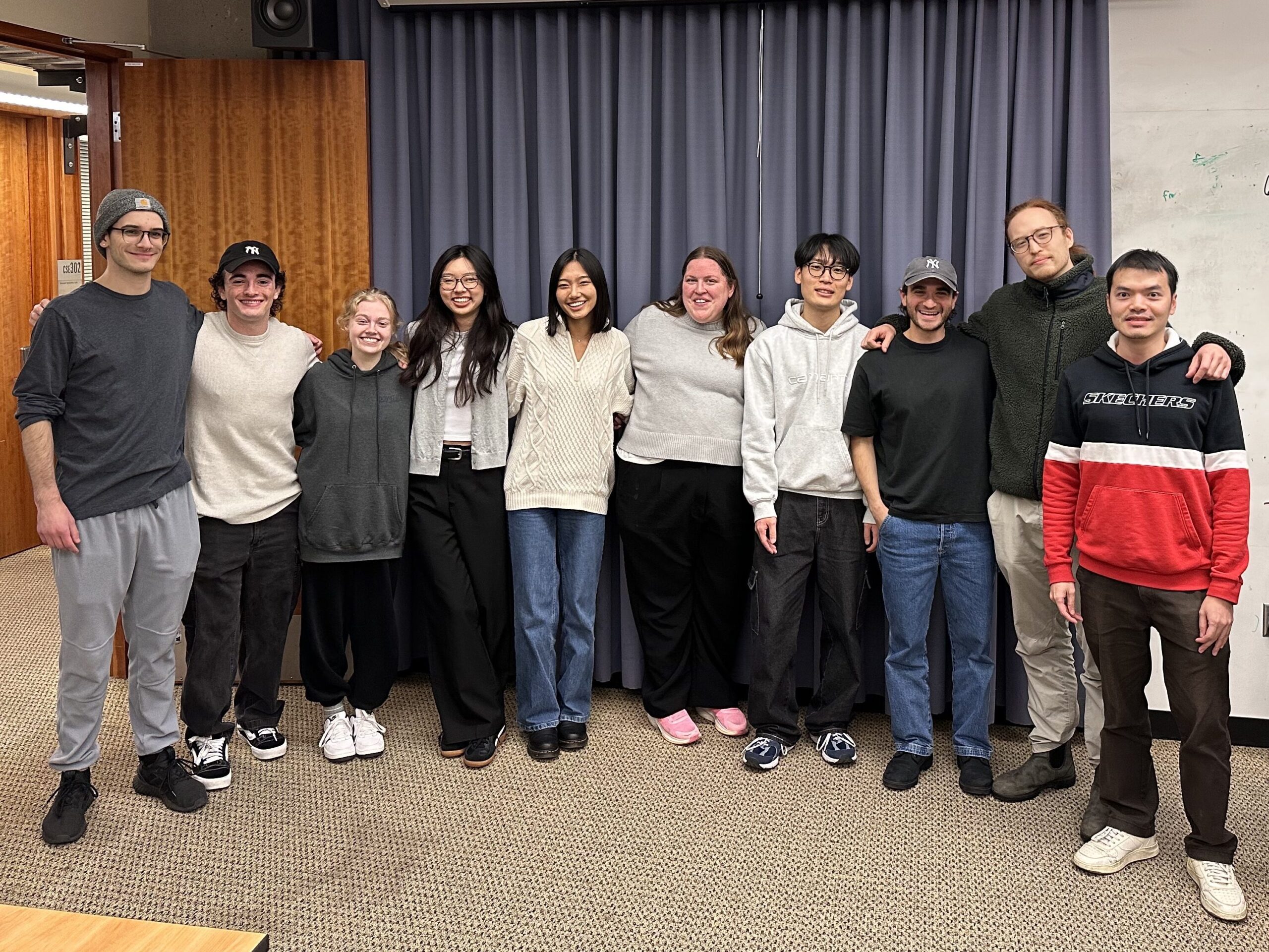 A group of transfer students post for a photo during class