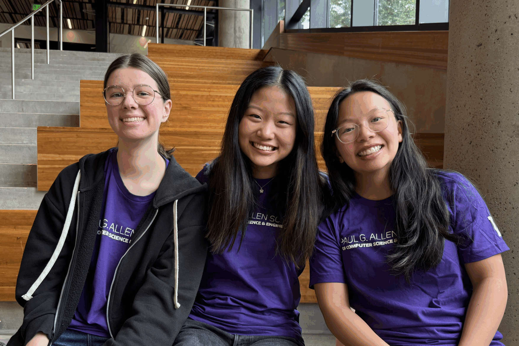 Three Allen School students wearing matching purple Allen School t-shirts