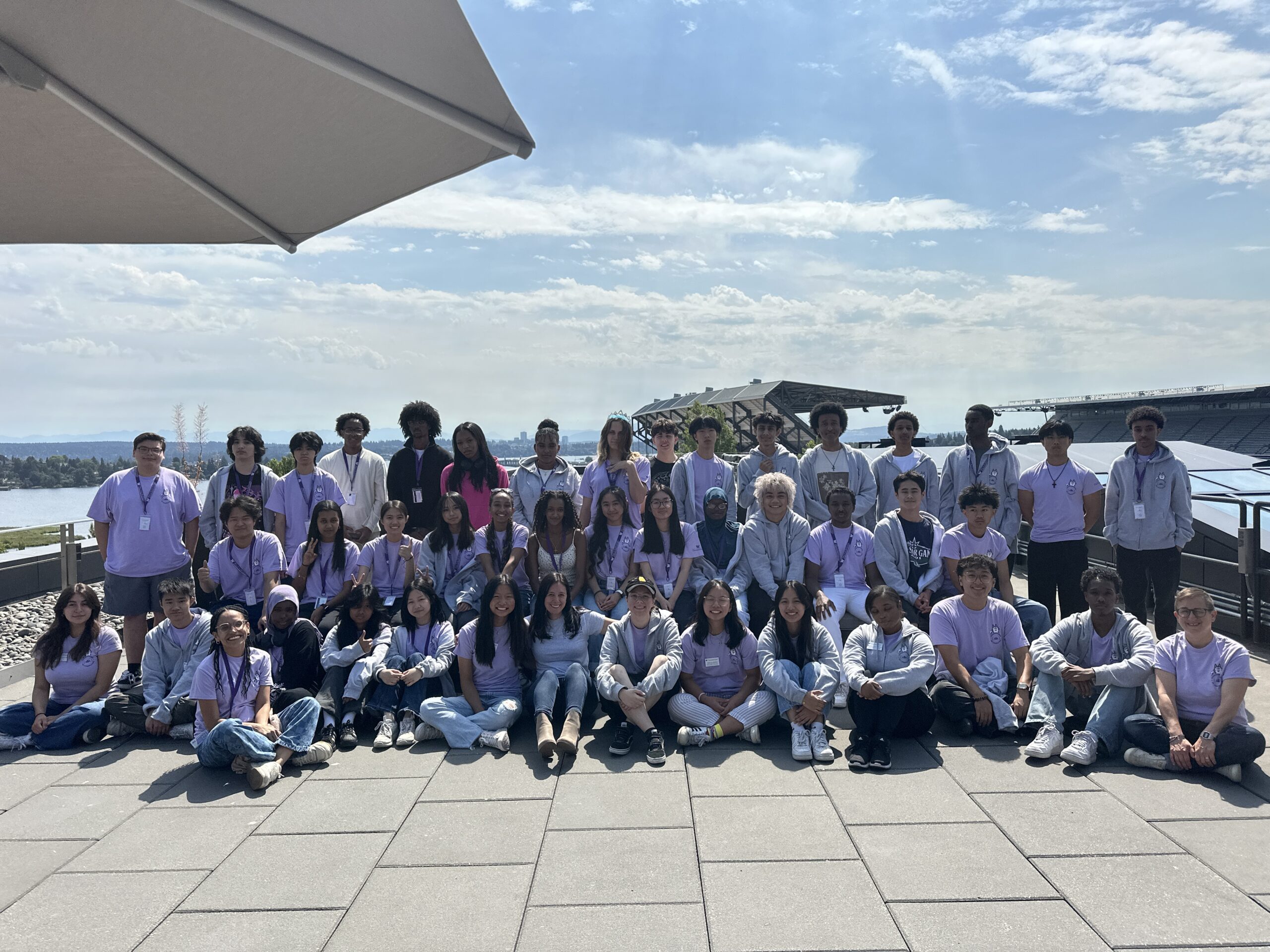 The 2025 Changemakers in Computing students & instructor team pose for a group photo with the husky stadium in the background