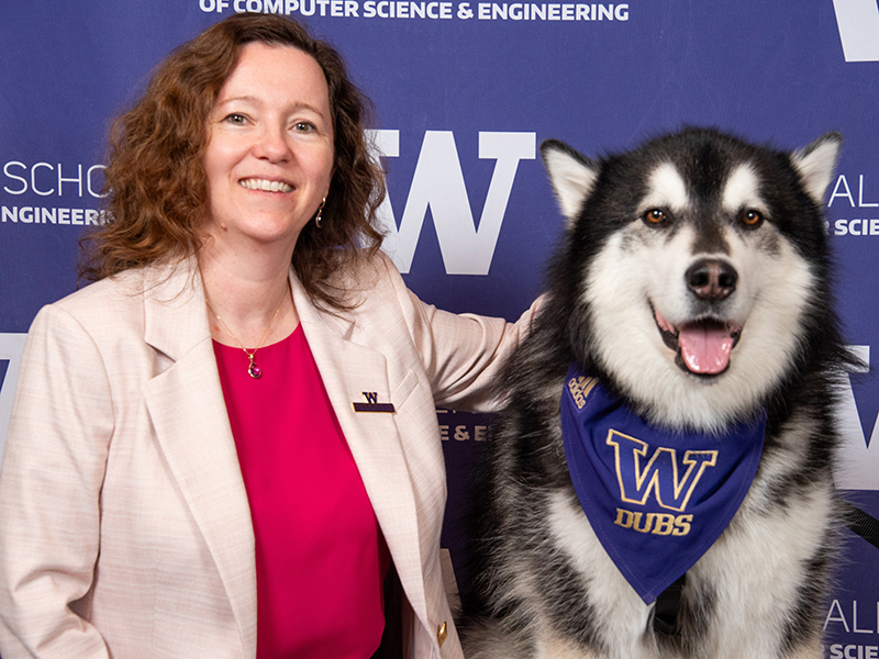 Magda Balazinska smiles as she poses next to Dubs the husky.