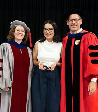 Nodira Khoussainova onstage holding award plaque flanked by Magda Balazinska and Dan Grossman in graduation regalia