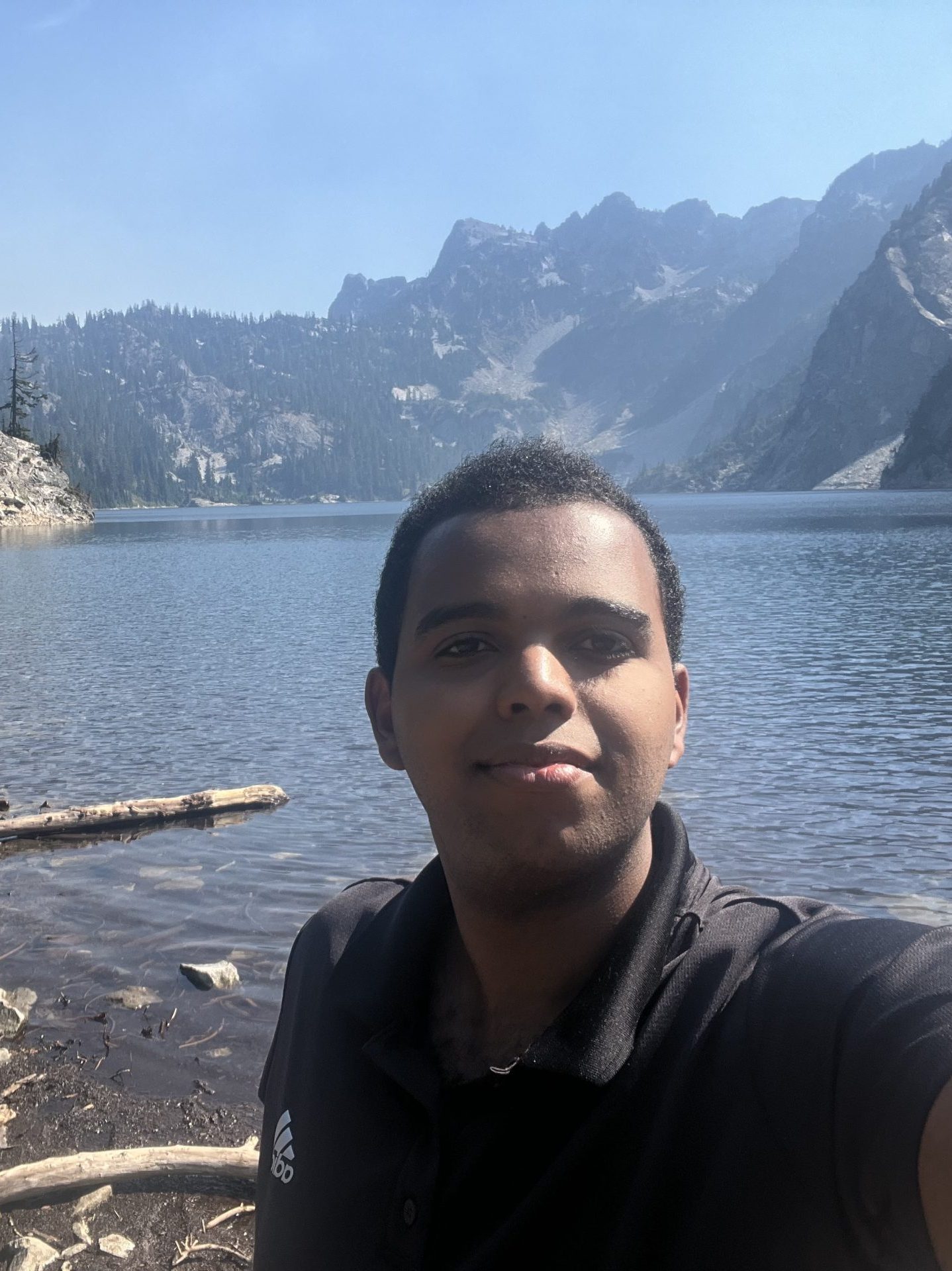 Nathan is in front of a lake (specifically Snow Lake) with a mountain range behind him