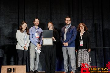 Hao Xu (center) accepts the EMNLP Best Paper Award among members of the conference program chairs.