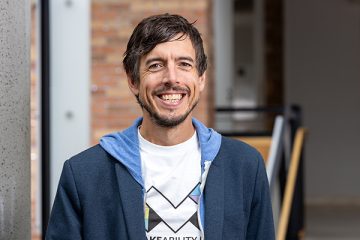 Portrait of Jon Froehlich wearing a shirt with the Makeability Lab logo on it.