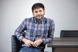 Ratul Mahajan sitting a desk facing the camera.