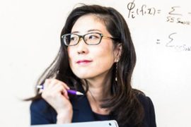 Su-In Lee holding a pen and looking off to the side
