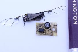 The RoboFly flying robot next to the TinySense sensor and a pencil for scale.