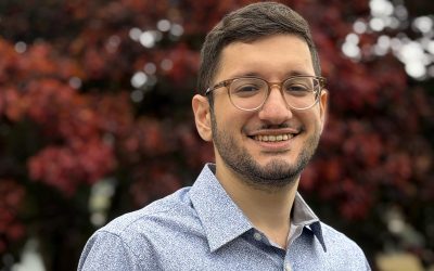 Malet Itani smiling in front of red fall foliage