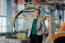 Portrait of Gail Murphy in front of an interactive science museum exhibit