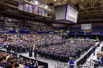 A crowded arena at a university graduation