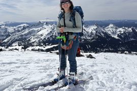 Kiana Ehsani standing on top of a snowy mountain peak smiling in ski gear