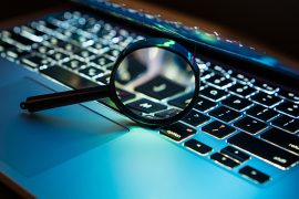 A magnifying glass positioned over the keyboard of a laptop computer