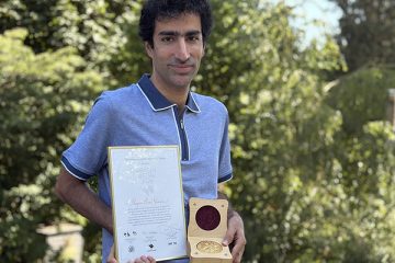 Shayan Oveis Gharan poses with award certificate and medal