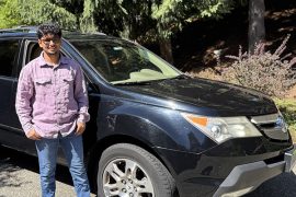 Aatish Parson stands next to a black SUV