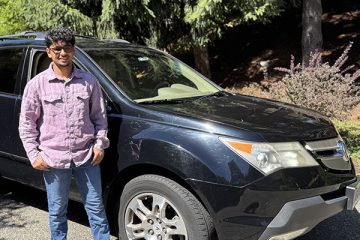 Aatish Parson stands next to a black SUV